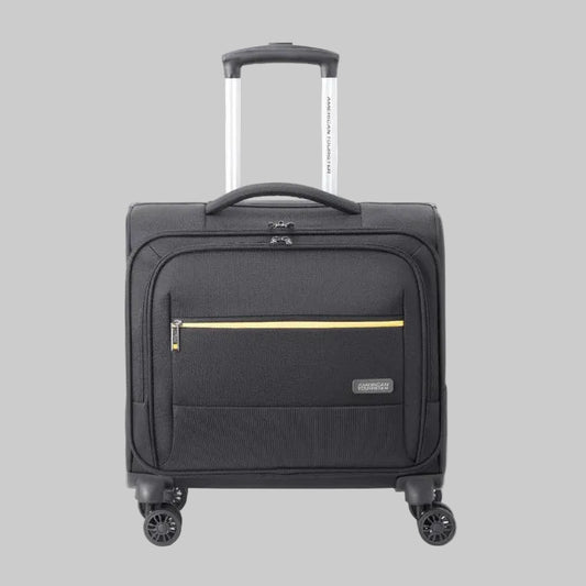A black rolling suitcase with a telescoping handle extended, featuring a front zippered pocket with a gold accent stripe and a small 'hertz' brand patch on the lower right front.